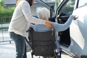 Asian senior woman patient sitting on wheelchair prepare get to her car