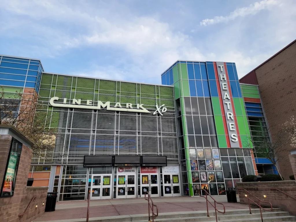 Front view of a CineMark XD movie theater with colorful signage and a row of glass doors at the entrance.